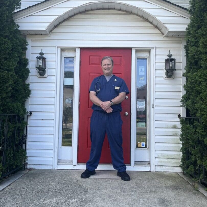 A man standing in front of a red door.